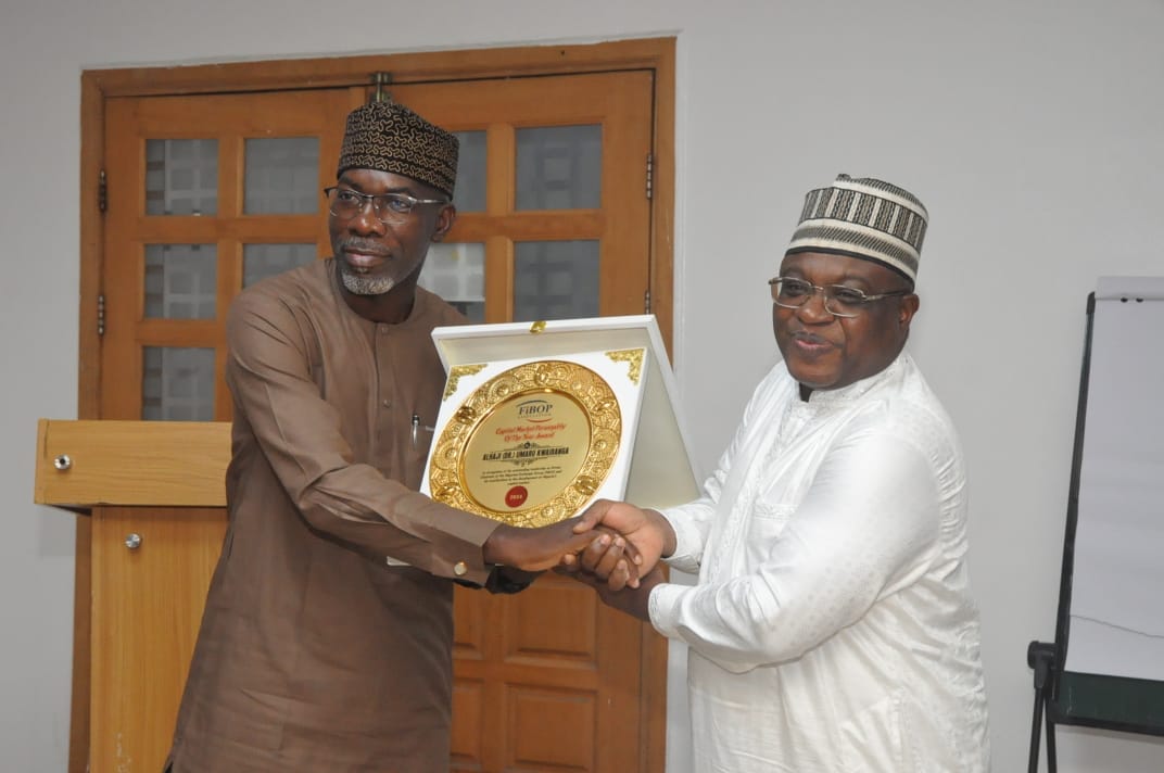 L-R: Michael Olufemi Olarinde, representing the Honourable Minister of Finance and Coordinating Minister of the Economy, Taiwo Oyedele, presenting the Capital Market Personality of the Year Award to the NGX Group Chairman, Dr. Umaru Kwairanga